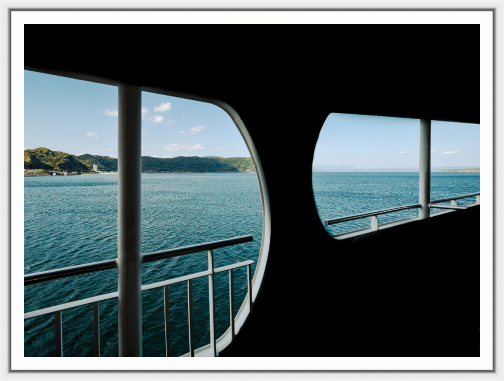 View of a body of water through a ship's porthole.