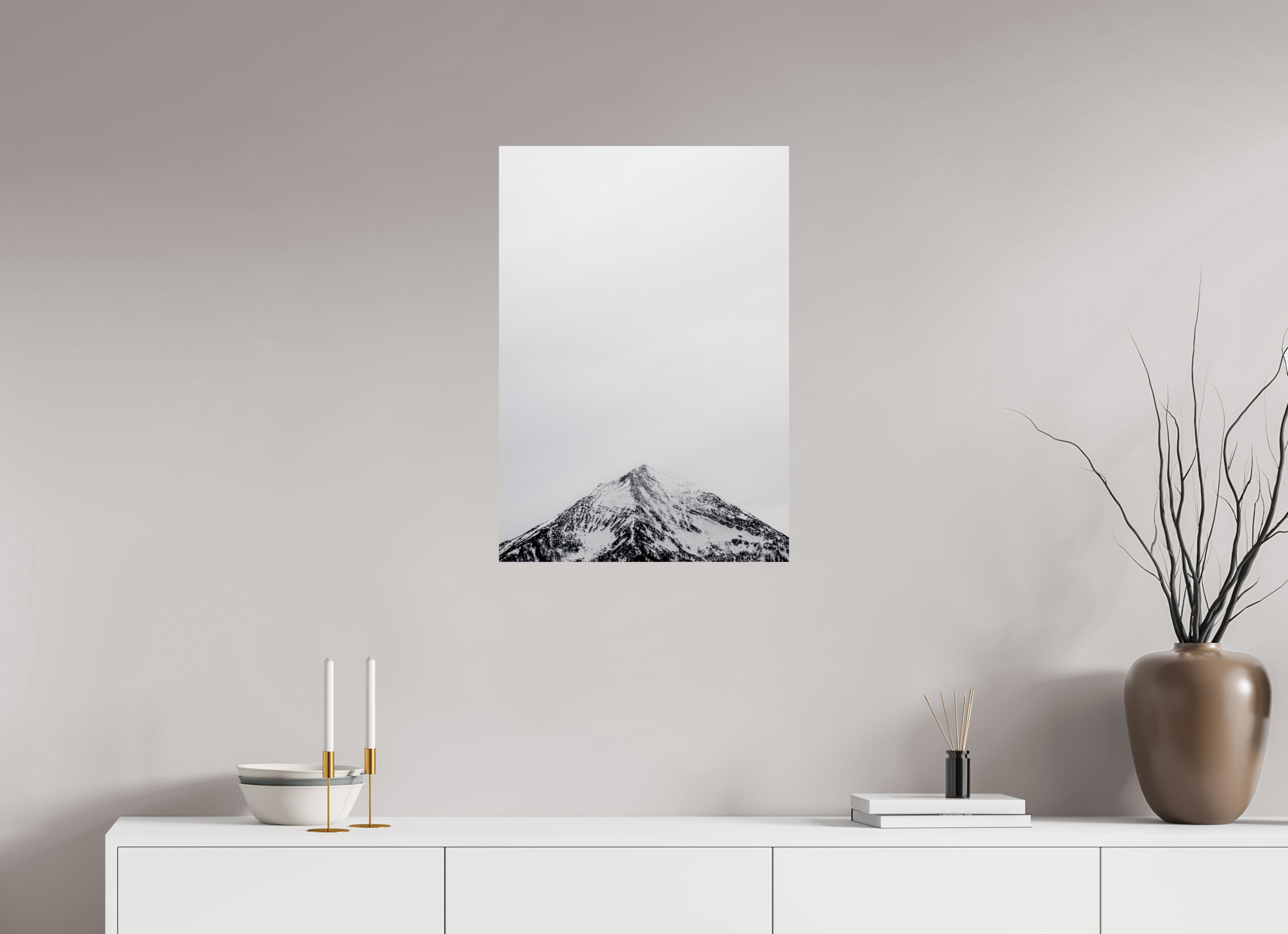Canvas print of a mountain landscape on a wall above a white cabinet with decorative items.