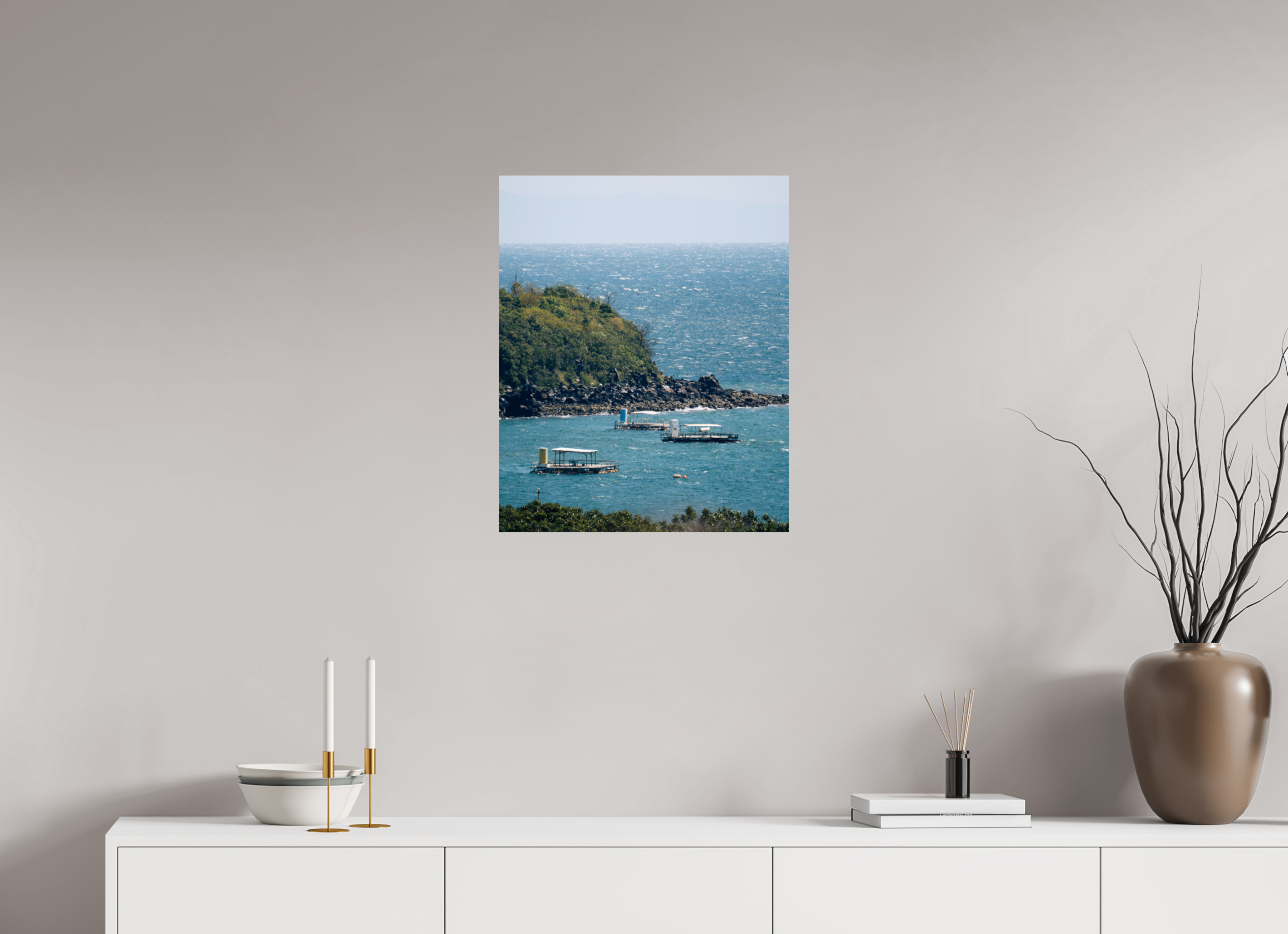 Canvas print of a coastal scene hanging on a wall above a white cabinet.