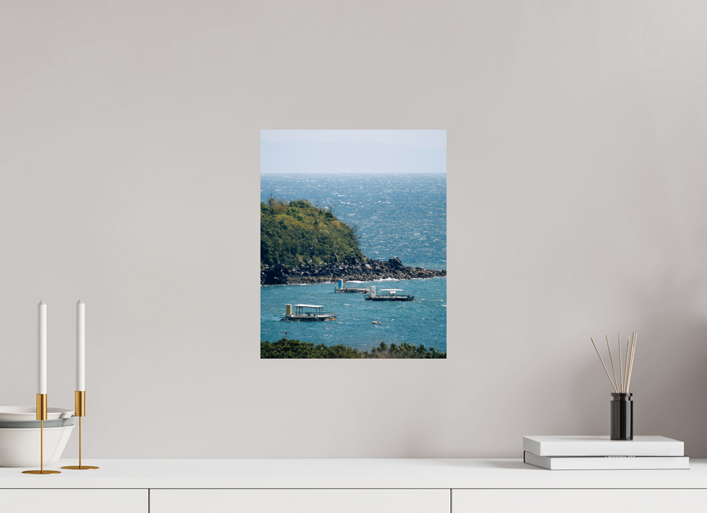 Canvas print of a coastal scene with boats on a white wall above a white cabinet.