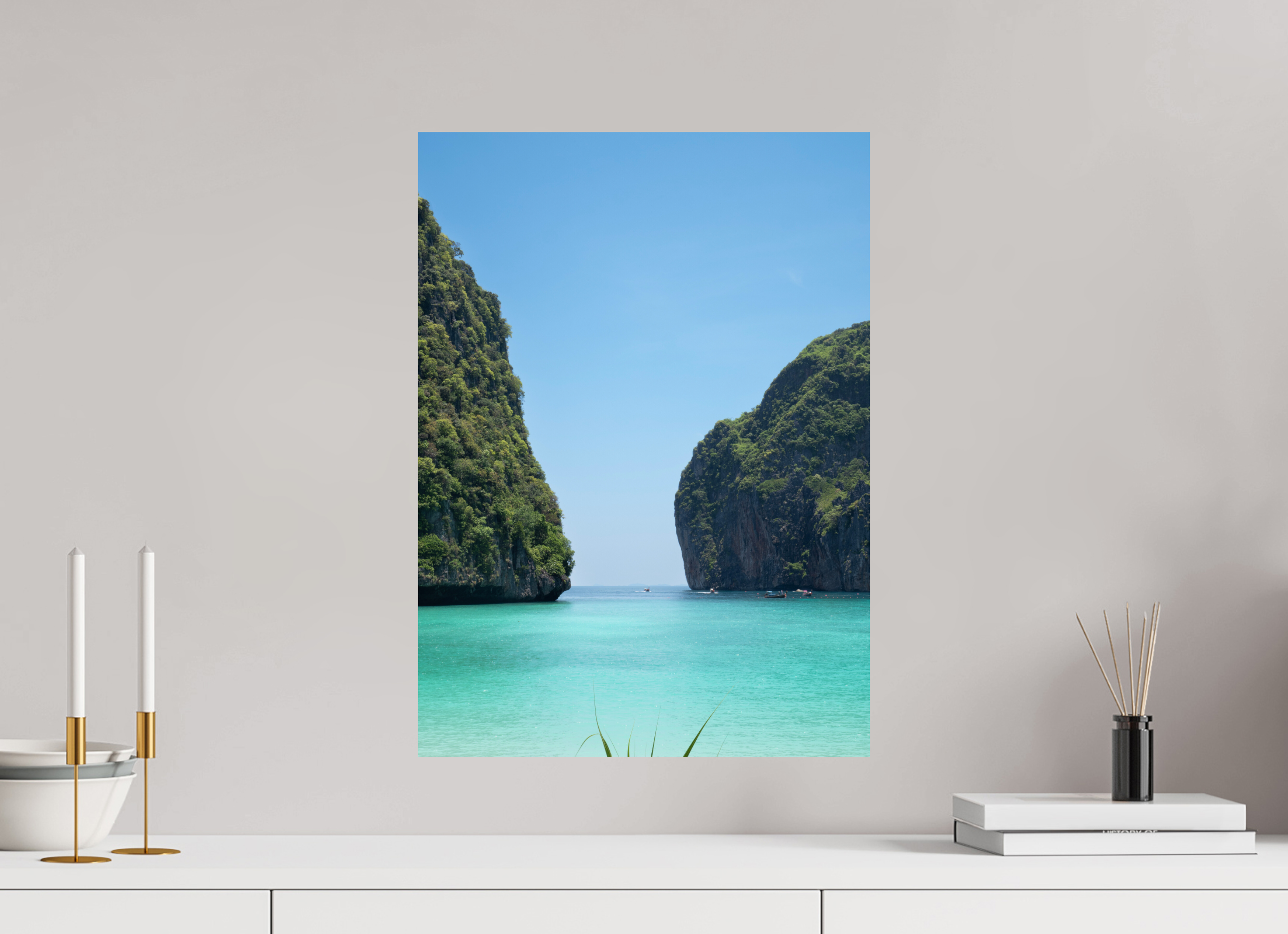 Canvas print of a tropical landscape with clear blue water and green cliffs on a wall above a white shelf.