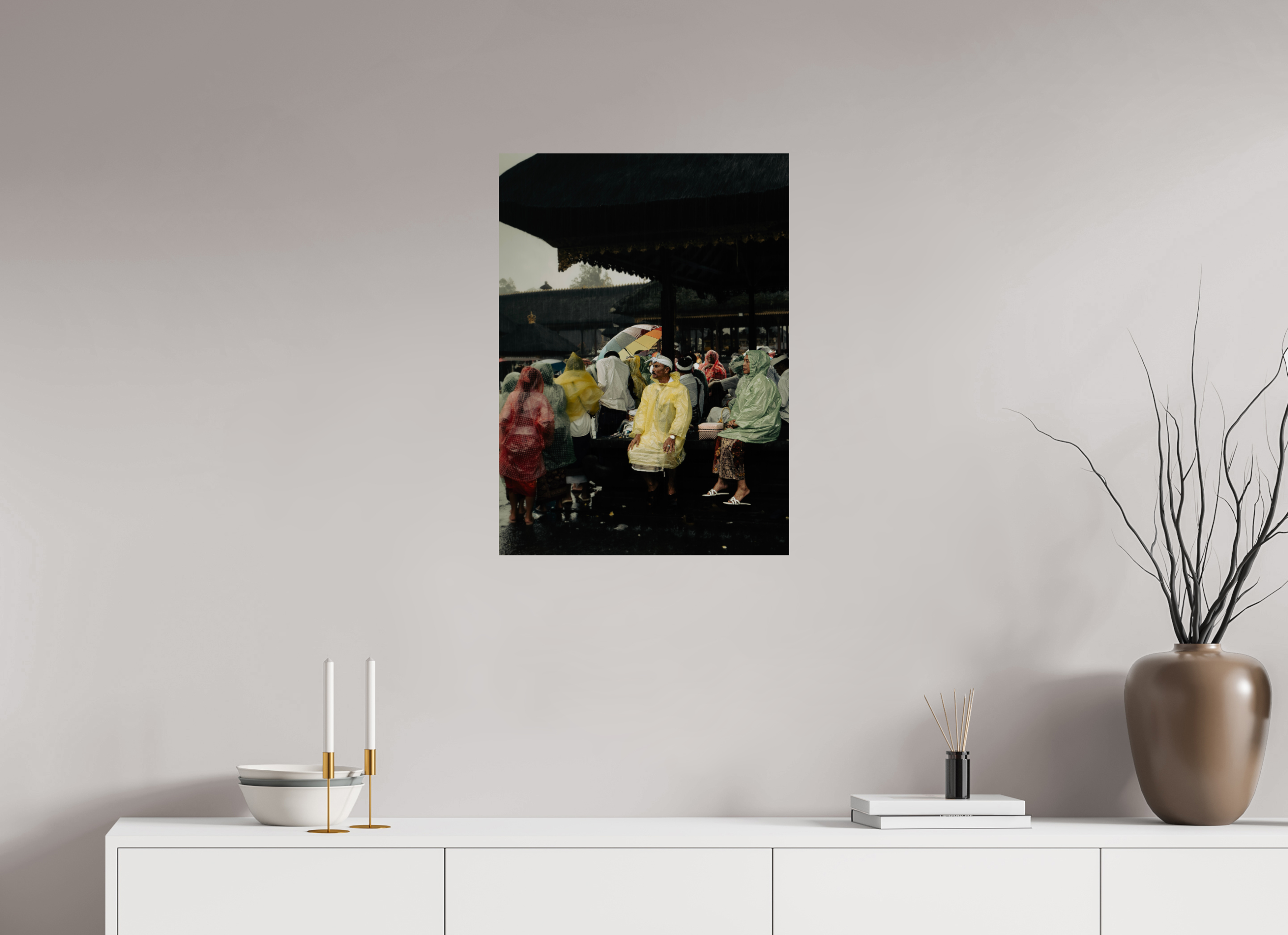 Framed artwork of a rainy street scene on a wall above a white console table.
